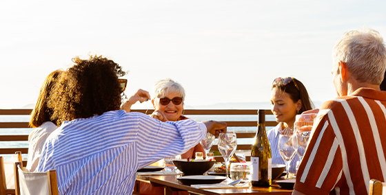 Gathering, people, table, sharing, meal, plant-based dishes, OLALA!, joy, smiles, delicious, feast, dining, community, friends, enjoyment